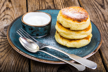 Hot delicious curd pancakes with fruit salad and yogurt