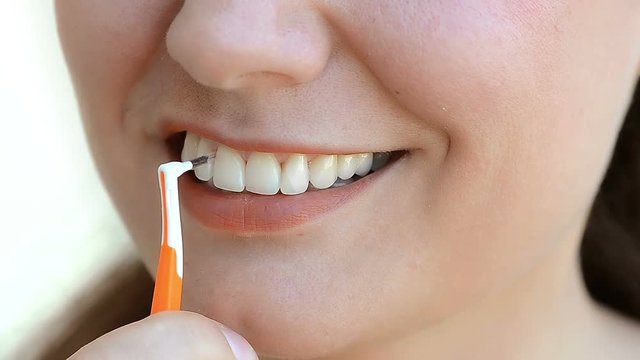 Young woman using interdental brush