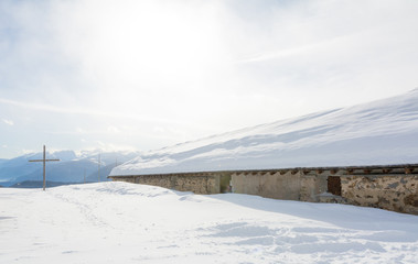 Panoramic view of idyllic winter wonderland with mountain tops and traditional mountain chalet in...