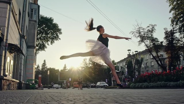 Young and pretty ballerina doing splits in the air