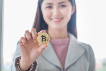 business woman holding gold bitcoin digital currency in hand