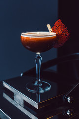 Cocktail with gold on a dark background with fruit chips