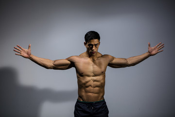 Fototapeta na wymiar Asian Bodybuilder Displaying Wingspan 