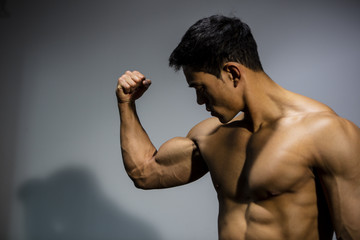 Fototapeta na wymiar Fitness Model Flexing Bicep Muscle
