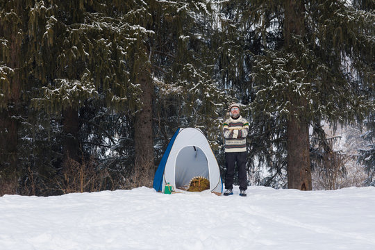 man in a tent in a winter forest