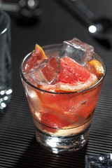 Cocktail juicy grapefruit. Vodka, ice and grapefruit on black table