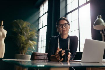  Female designer sitting at her desk with coffee