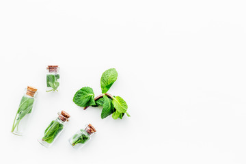 Herbal medicine. Healing herbs in small bottles on white background top view copy space