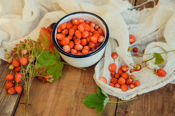Tea cup with strawberries with red raspberries on white background