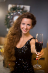 Beautiful young girl in festive attire with a glass of red wine. girl is blurry