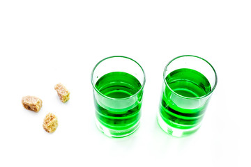 Absinthe shots near sugar cubes on white background top view copy space