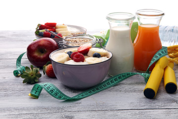 muesli with dairy and fruit, healthy lifestyle. bowl of cereal, fruit and dumbbell