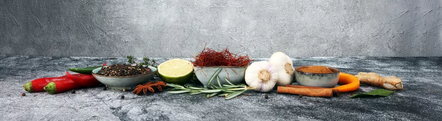 Fotobehang Aroma Specerijen en kruiden op grijze achtergrond. Voedsel en keuken ingrediënten.