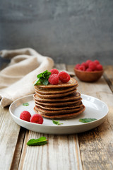 Homemade pancakes decorated with fresh raspberries. Wholemeal flour with cocoa and nut paste
