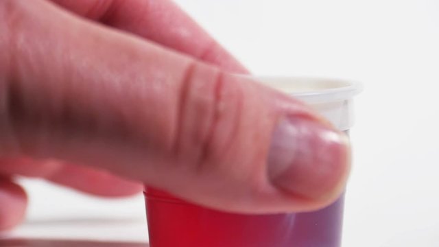 Red Cold Medicine Being Picked Up Isolated on White Slow Motion