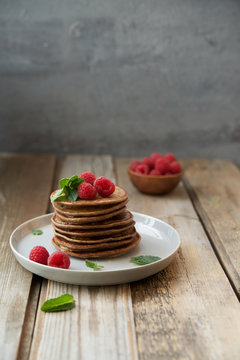 Homemade pancakes decorated with fresh raspberries. Wholemeal flour with cocoa and nut paste
