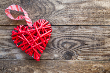 red wicker heart on a wooden background