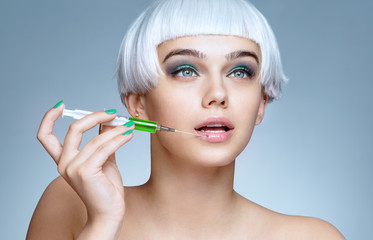 Beautiful woman with syringe making rejuvenate injection. Clean Beauty concept