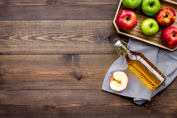 Bottle of fresh cider near autumn apples. Dark wooden background top view space for text