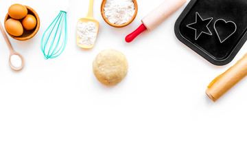 Ball of fresh raw dough near ingedients and cookware on white background top view copy space