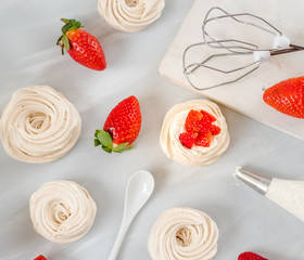 A small meringue Pavlova dessert with some strawberry slices . Top view. pattern