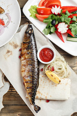 grilled mackerel and a salad of fresh vegetables. Serving on a wooden Board on a rustic table. Barbecue restaurant menu, a series of photos of different meats anf fish
