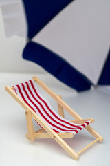 striped beach chair and beach umbrella