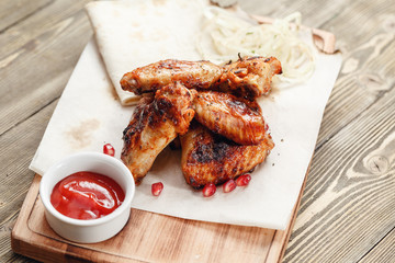 grilled chicken wings. Serving on a wooden Board on a rustic table. Barbecue restaurant menu, a series of photos of different meats