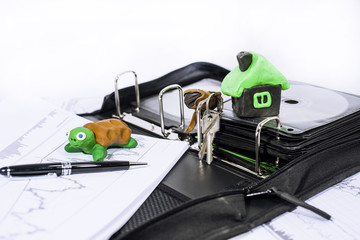 Naklejka premium Abstract photo of slow property buying process. Documents case with turtle.