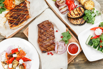 grilled steak of marble beef and pork. Serving on a wooden Board on a rustic table. Barbecue restaurant menu, a series of photos of different meats