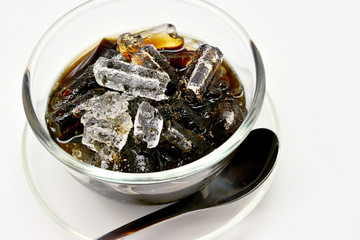 Close-up grass jelly (Mesona chinensis) with iced on white background.