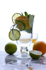 Mojito with lime and lemon and mint, cocktail with ice in a glass cup, soft drink with ice on a light background, empty space, cocktail pop art, toned background, summer drink