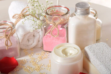 Obraz na płótnie Canvas rose bath salt for relaxation and for feet with face cream and rose petals