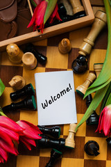 Bouquet of red tulips, chocolate hearts and chess with tag