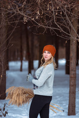 beautiful girl in a fur vest walks in a field in the snow