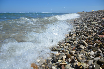Sea water splash on stony beach