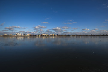 City reflection in a frozen lake on sunset