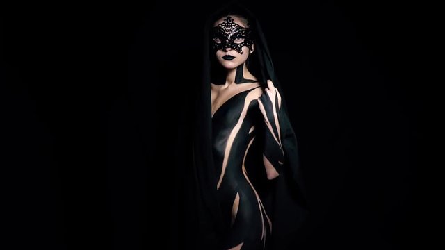 A mystical woman in a mask and black patterns on her body