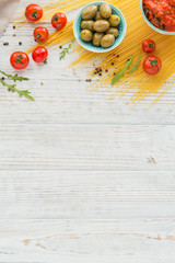 Naklejka na ściany i meble Ingredients for preparation pasta spaghetti - tomato, olive oil, spices, herbs, green olives, tomato sauce