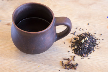 Fugural still life photo image of clay cup on wooden table with little pieces of tea