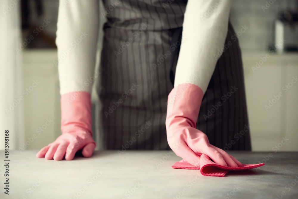 Wall mural woman in pink rubber protective gloves wiping dust and dirty. cleaning concept, banner, copy space