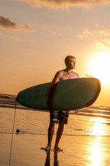 Surfer with surfboard on the beach