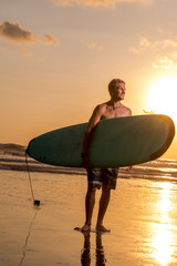 Surfer with surfboard on the beach