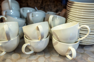 Clean empty dishes stacked on kitchen shelf