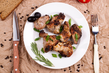 Shish kebab with onions and rosemary and tomatoes on a plate