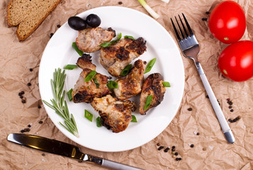 Shish kebab with onions and rosemary and tomatoes on a plate