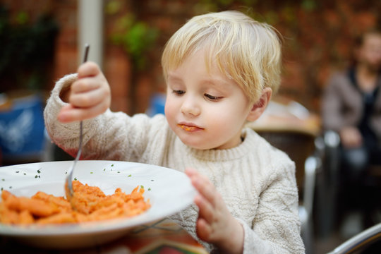 Cute Toddler Boy Eating Pasta In Italian Indoors Restaurant