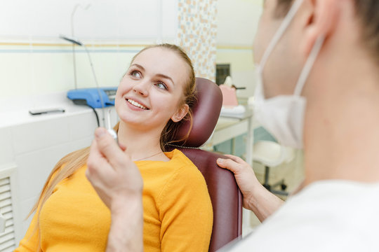 A smiling woman at the dental chair ready for a check-up in clinic