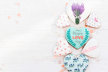 happy valentine's day greeting card. happy love day text on cookie hearts and flowers on white rustic wooden background with confetti flat lay. space for text . mock-up