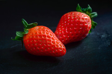 Strawberry fruit on black stone background. . Delicious and health fresh berries.
